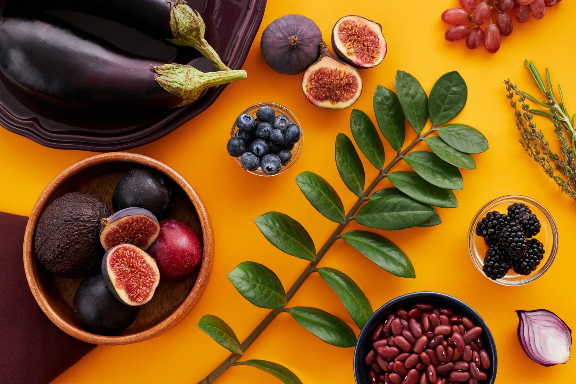 leaves among fruits and vegetables on orange background